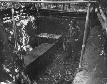 A Digger with a rifle checks one of eight in ground operating theatres near the wards at the K76A Hospital. 