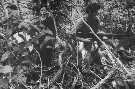 A VietCong patient leads element of 6 RAR/NZ (ANZAC) to another ward in K76A Hospital where the machine gunner is engaged. 