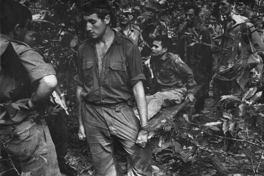 Diggers from 6 RAR/NZ (ANZAC) carry a wounded VietCong prisoner around the mountain at  K76A Hospital captured during Operation Marsden.  