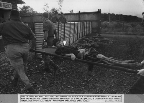 A wounded NVA/VietCong captured in the wards of K76A  NVA/VietCong hospital, is carried into the 8th Field Ambulance Hospital at 1st Australian Task Force Base.