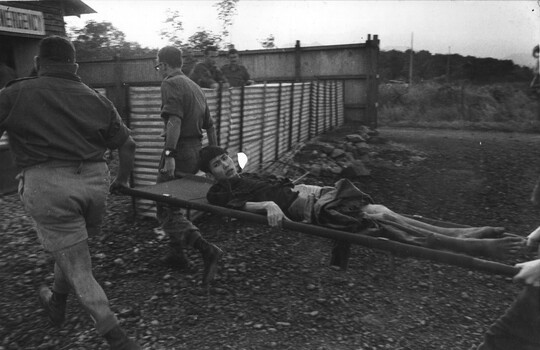A wounded NVA/VietCong captured in the wards of K76A  NVA/VietCong hospital, is carried into the 8th Field Ambulance Hospital at 1st Australian Task Force Base.