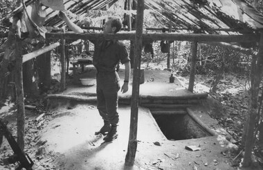A photograph of a Digger checking out the Doctor's Quarters near one of the wards at the NVA/VietCong K76A Hospital captured during Operation Marsden.