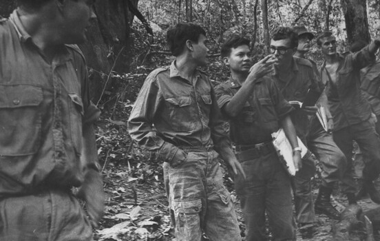 A photograph of A Viet Cong patient leads elements of 6 RAR/NZ (ANZAC) to another ward in the K76A Hospital. 