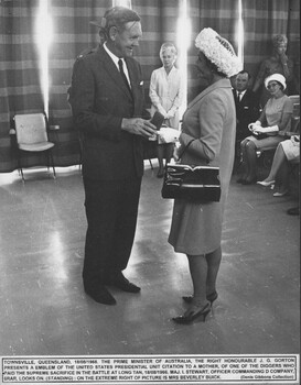 A photograph at Townsville, 18/08/1968. The Prime Minister, John Gorton presents the U.S. Presidential Unit Citation to a mother of a Diggers who died