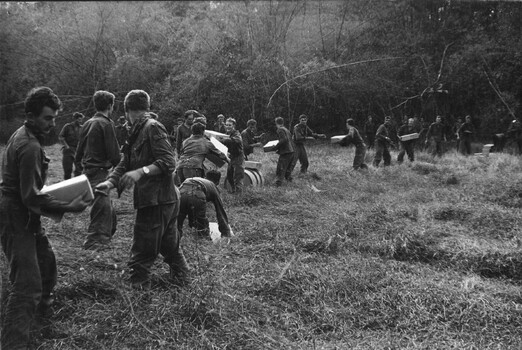 A photograph of Diggers from 4 RAR/NZ (ANZAC) unloading store rations and other essential supplies delivered to the field. 