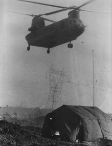 A photograph of a US Army CH47 Chinook helicopter delivering supplies to A Battery 2/35th US Artillery at Base Bien Hoa.