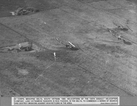 A photograph of helicopters of the 135th Assalt Helicopter Company land Vietnamese rangers in rice paddies, in the Delta.