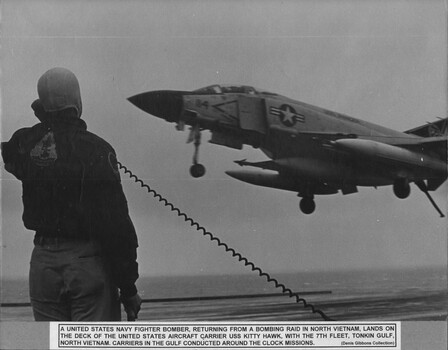 A photograph of a U. S. Navy fighter bomber returning from a bombing raid in North Vietnam. 