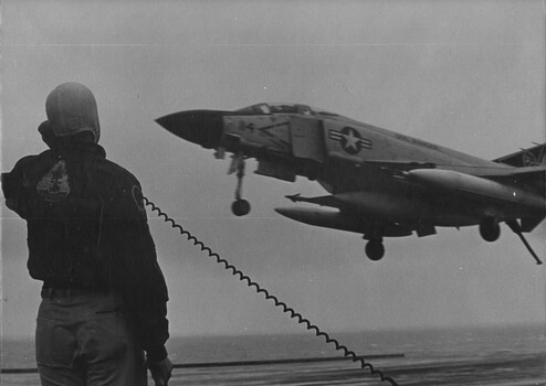 A photograph of a U. S. Navy fighter bomber returning from a bombing raid in North Vietnam. 