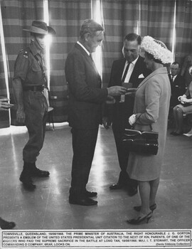 A photograph in Townsville 8/08/1968. The P. M. John Gorton presents an emblem of the U.S.Presidential Unit Citation to next of kins.