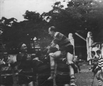 A photograph of Lt Col Naughton OBE CO 1st Field Hospital, is lifted onto the shoulders of his team mates during a rugby union game.