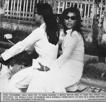 A photograph of Two Vietnamese girls sharing a moped motor bike at Vung Tau, Phuoc Tuy Province.