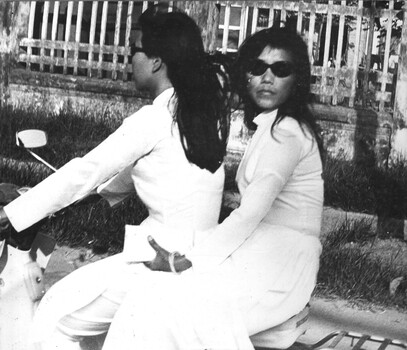A photograph of Two Vietnamese girls sharing a moped motor bike at Vung Tau, Phuoc Tuy Province.