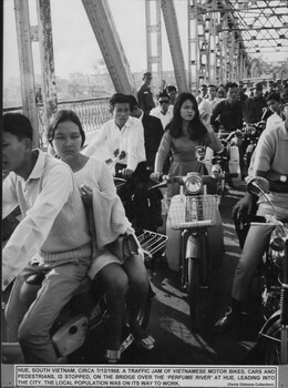 A photograph of Hue, South vietnam, Circa 7th Dec 1968. A traffic jam of Vietnamese motor bikes, cars and pedestrians. 