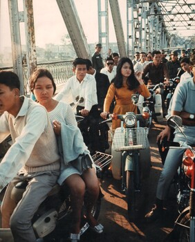 A photograph of Hue, South vietnam, Circa 7th Dec 1968. A traffic jam of Vietnamese motor bikes, cars and pedestrians. 