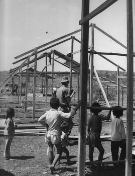 A photograph of Pte Mike Coyle, 1st Australian Civil Affairs Unit supervises Vietnamese in the construction of their new village at Ap Sui Nge. 