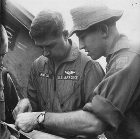 A photograph of Lt Colin Scott DFC, shows Capt Dick Niemela an American Forward Air Controller, the area coordinates, of a large NVA/VietCong force.