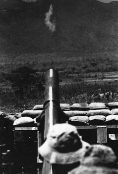 A photograph at Phuoc Tuy Province, July 1966, A US 105mm towed Howitzer firing on targets in the Nui Thai Vai hills. 