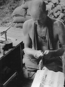 104 Battery RAA Gunner Sgt Peter Tilbrook at one of his spare time occupations, making model airplane ashtrays from empty shells cases. 