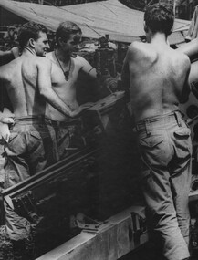 Bdr Beasley watches Gnr Dave Thomas adjust the gun sight, while Gnr Owen Herbert readies the gun for firing.