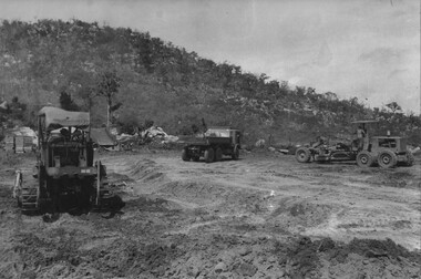 Engineers from 17 Construction Squadron use a bulldozer and road grader to prepare the road surface for sealing. 