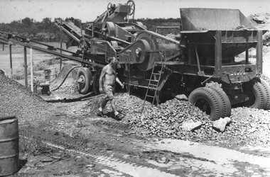 An Engineer from 17 Construction Squadron operates a mobile crusher used to prepare rock material of all sizes.