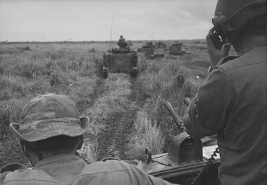 Armoured Personnel Carriers in open country in Phuoc Tuy Province. The crew Commander on the right of the photograph is Cpl Normie Rowe.