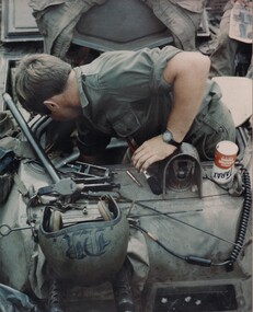 Cpl Normie Rowe strips, cleans and services the twin 30 calibre machine gun on his APC. 