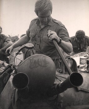 Cpl Normie Rowe, promoted to crew commander of an APC, cleans and services the twin 30 calibre machine gun on his APC.
