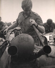 Cpl Normie Rowe, promoted to crew commander of an APC, cleans and services the twin 30 calibre machine gun on his APC.