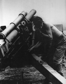 A 104 Battery,  Royal Australian Artillery Gunner turns his head and shields his ear as he fires the gun at Fire support Base "Betty".  
