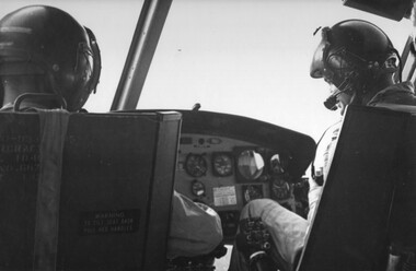 Pilots at the controls of a Huey 'Slick' aircraft of RAAF's 9 Squadron.  