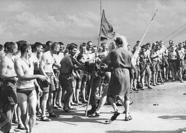 A digger from 9th Battalion, RAR watch as the courtiers of "King Neptune" during the "crossing of the line" ceremony. 