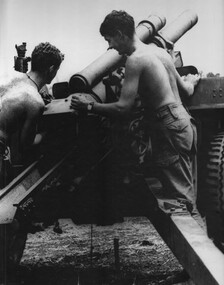 104 Battery, Royal Australian Artillery Gunner , rams a shell home while the gun is readied for firing at Fire Support Base "Betty".