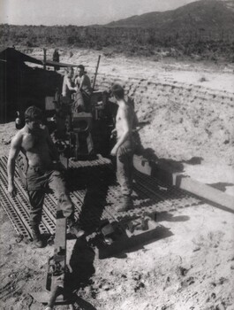 Gunners of 104 Battery Royal Australian Artillery at Fire Base Betty carry our maintenance on their gun during a lull in fighting. 