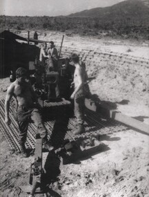 Gunners of 104 Battery Royal Australian Artillery at Fire Base Betty carry our maintenance on their gun during a lull in fighting. 