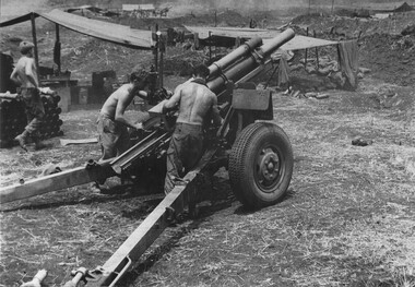 Gnr Stuart Brooksby walks back into the 105mm gun position as Gnr Smith checks the gun sight and Grn Dick Gray makes adjustment. 