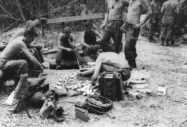Gunners of 104 Battery Royal Australian Artillery at Fire Base Betty divide up cigarettes which had just arrived. 