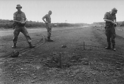 Capt Tony Eaton from the 1st ATF Artillery Intelligence Officer about to take a compass reading of the incoming direction of a NVA/VietCong 107mm rocket.