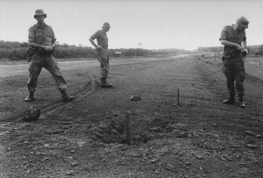 Capt Tony Eaton from the 1st ATF Artillery Intelligence Officer about to take a compass reading of the incoming direction of a NVA/VietCong 107mm rocket.