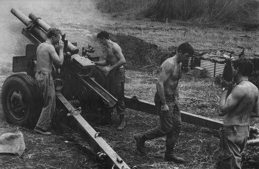 Four soldiers operating a howitzer.