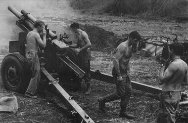 Four soldiers operating a howitzer.