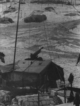 A photograph of a quiet time, in a gun detachment area at an Australian Fire Support Base, in the sand dunes.