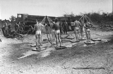 A photograph of 104 Battery Gunners at 4 RAR/NZ (ANZAC) Fire Support Base 'Betty' enjoying a fresh shower supplied by a Mobile Shower Unit. 