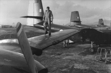 A photograph of the Crew Chief, Cpl Allan Hudson of an RAAF No 35 Squadron Caribou doing his pre-flight check. 