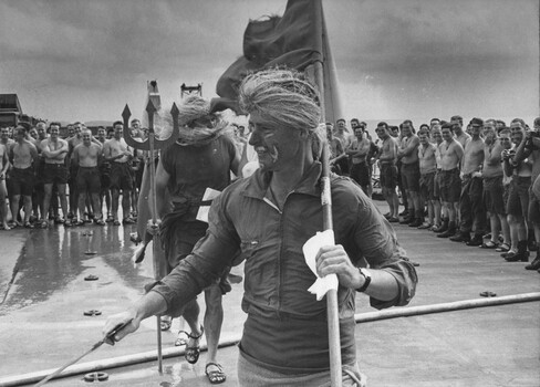 A photograph of Diggers of 9th Battalion, Royal Australian Regiment watching as the courtiers of 'King Neptune' during the 'crossing of the line' ceremony. 