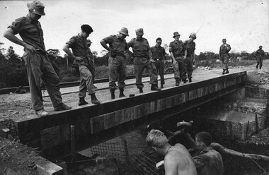 A photograph of the 1st Australian Task force Commander Brigadier Stewart Weir MC inspects a new bridge built by Australian Engineers. 