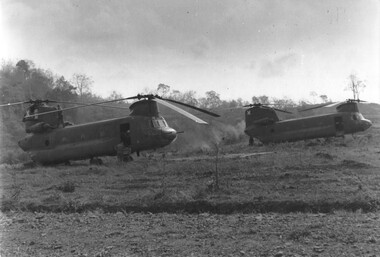 A photograph of United States Army Chinook medium helicopters wait on Kanga pad at 1 ATF Base Nui Dat, Phuoc Tuy Province. 