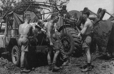 A photograph of diggers with a mobile service unit from the Royal Australian Mechanical and Electrical Engineers.