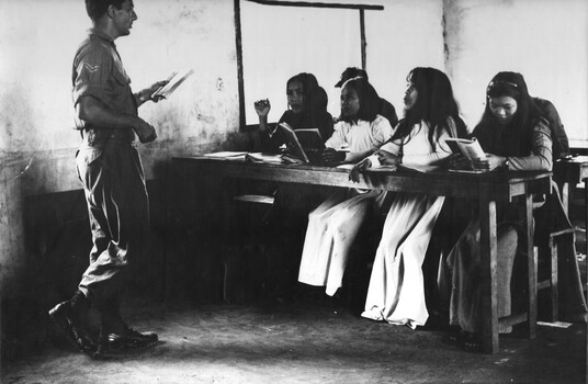 A photograph of an Australian linguist, interpreter and educational Corporal, conducting an  English class in the Phuoc Tuy Province capital Baria. 